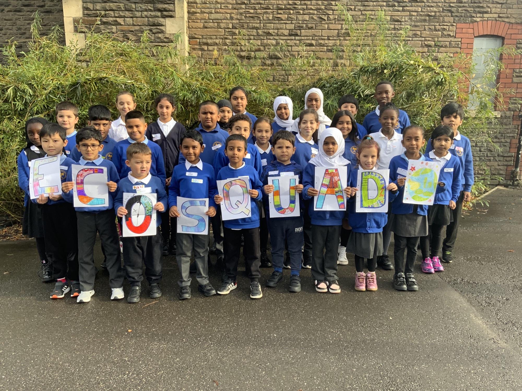 A group of children holding letters to spell out Eco Squad.